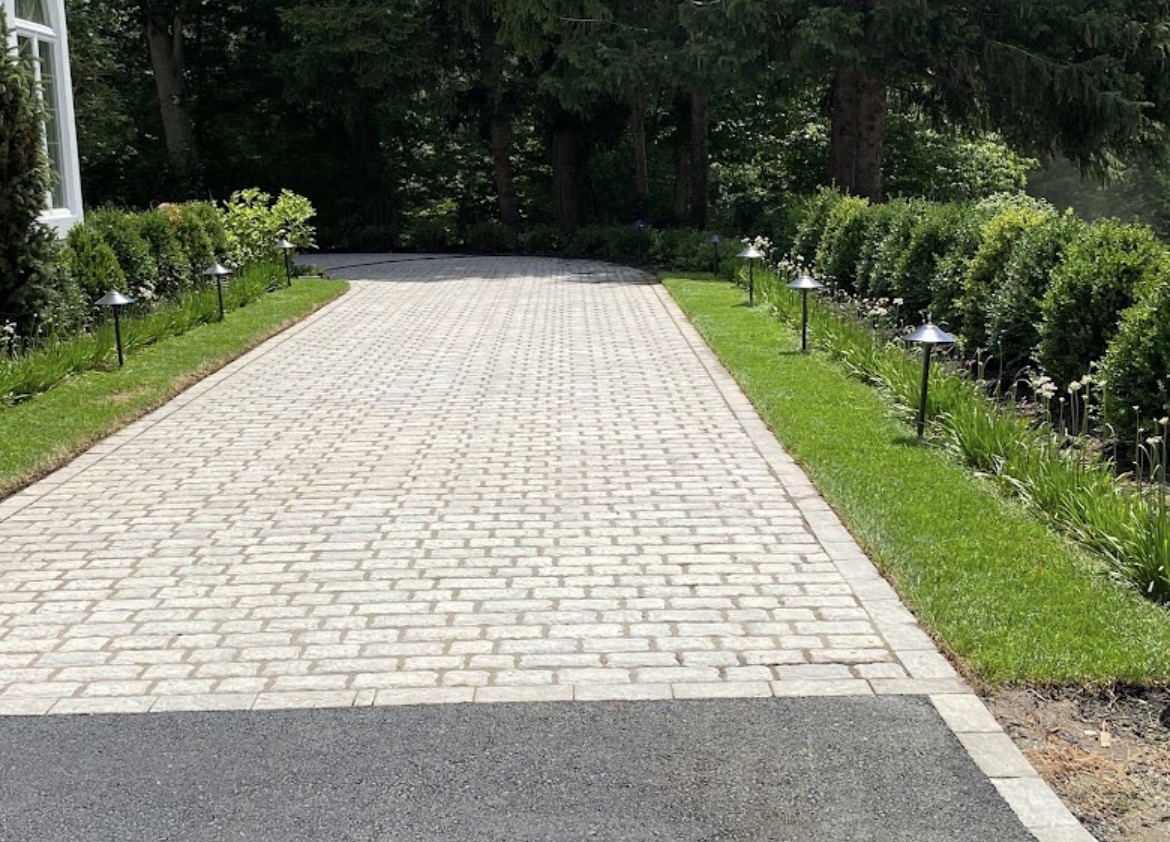 Cobblestone paver driveway with manicured hedges and low-voltage path lighting installed by Sierra
